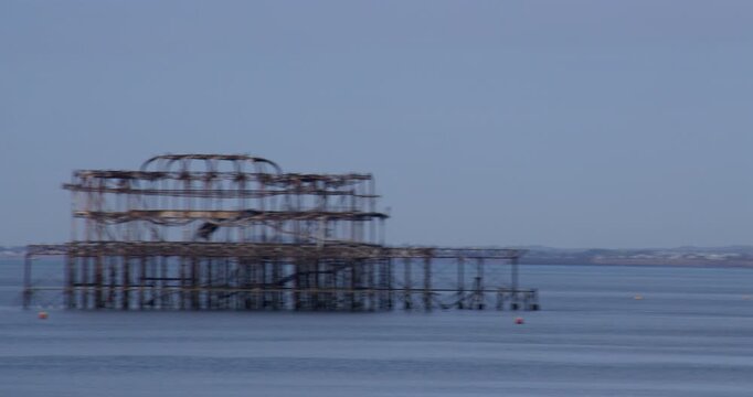 Wide panning shot right to left from the beach onto the Dialect Brighton West pier