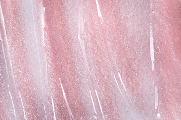 Fototapeta premium Pink glitter spreading on surface forming cosmetic texture background