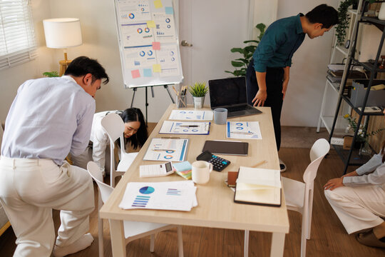Office workers practicing earthquake safety drill under table