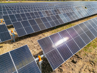 Modern photovoltaic modules installed on ground mounted racking systems at a solar power plant construction site designed for sustainable clean electricity generation © K