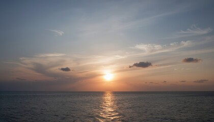 Fototapeta premium Serene Sunset Over Calm Ocean with Golden Reflections and Soft Clouds at Dusk