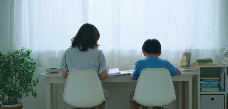 窓辺で勉強する親子