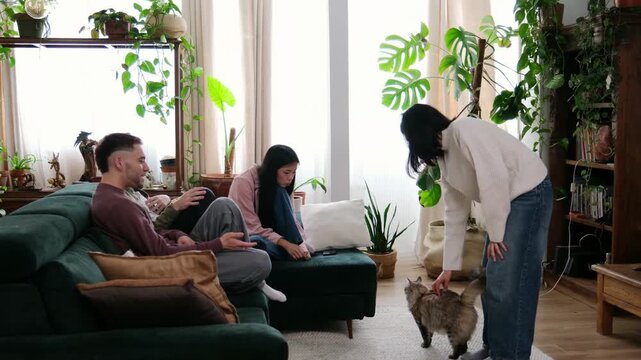 Group of friends having fun at home playing charades in their plant filled living room