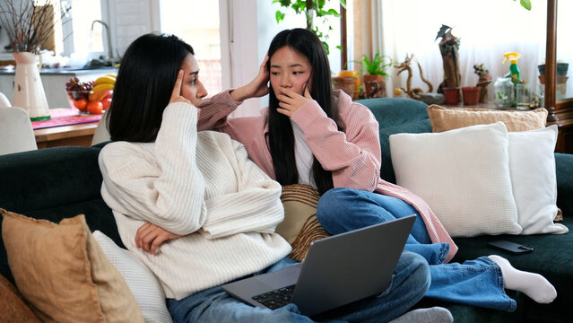 Young women discussing online problem at home, feeling stressed and concerned