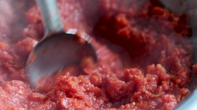 Close-up of gajar ka halwa being cooked and stirred in a pan. Traditional Indian sweet dish preparation, rich texture, hot dessert, rural lifestyle, poverty, slum village poor india concept.  