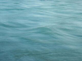 Obraz premium Oceanic Reverie: Abstract capture of the ocean, where water undulates, conveying a sensation of serenity and fluidity. The photograph portrays the tranquility of the sea.