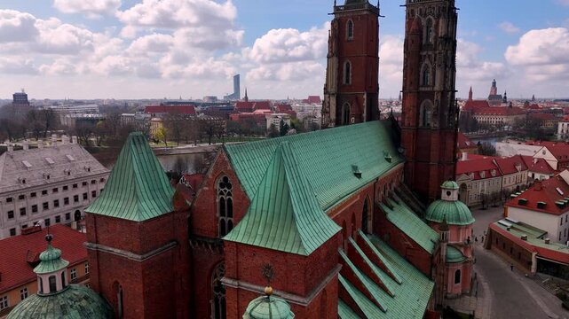 Aerial drone view of Ostrow Tumski in Wroclaw, Poland, historic Cathedral of St. John the Baptist with green copper roofs, Odra river, city panorama, sunny day, travel photography.