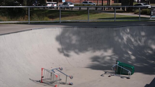 Abandoned shopping trolleys dumped inside a skate park bowl in Point Cook, Melbourne, Australia.  Social issue of anti social behaviour and vandalism at public community space