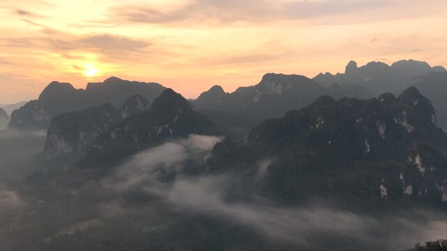 Experience the stunning sunrise illuminating the misty peaks of Khao Sok National Park in Thailand. This breathtaking moment captures the essence of nature's beauty and tranquility.