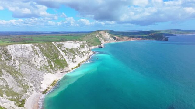 Tracking aerial shot of white cliffs along the Jurassic Coast near Lulworth Cove, Dorset, UK