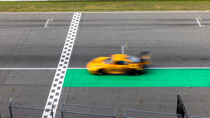 Fototapeta premium Motion blur, Race car racing on speed track, race car on road crossing start and finish line, Target business achieve and victory concept. .