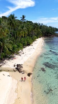 Discover the tranquil beauty of Koh Kood Island in Thailand, where soft sandy beaches meet crystal-clear waters. A couple of men and women on a romantic stroll or a peaceful retreat.