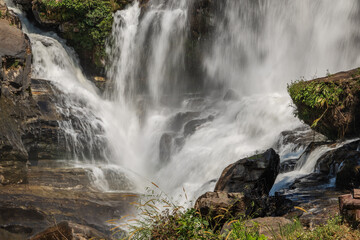 Majestic Wachirathan Waterfall in Doi Inthanon National Park, Thailand, cascades powerfully over ancient rock formations. Long exposure creates a serene, silky flow of water amidst lush natural © BestTravelPhotos