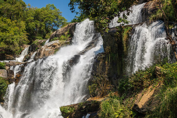 Majestic Wachirathan Waterfall cascades powerfully over multiple rocky tiers amidst lush tropical forest in Doi Inthanon National Park, Chiang Mai, Thailand. A vibrant natural spectacle. © BestTravelPhotos