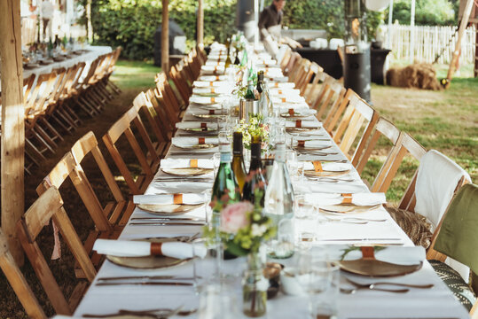 Beautifully set long tables for outdoor dinner during the wedding