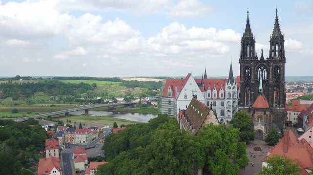 View of Meissen's castle hill featuring the Gothic Cathedral and Albrechtsburg Castle. The ensemble towers over the Elbe and is known as the cradle of Saxony, surrounded by lush greenery.