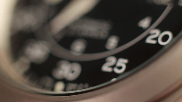 Macro close up of an automatic mechanical field watch with moving arms
