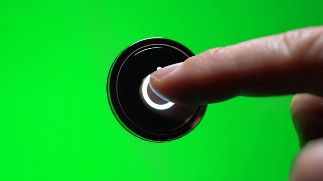 Finger presses illuminated power button against green background
