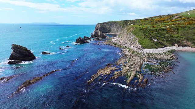 Aerial shot flying low over rocky coastline near Lulworth Cove, Dorset