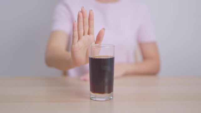 Healthy woman hand stop sign to refuse soft drink and soda, say no to sugar and carbonated beverage, healthy lifestyle, Acid reflux, Heartburn and Gastritis concept
