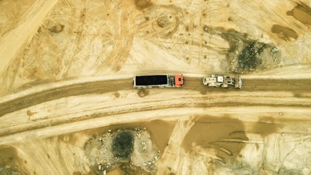 Aerial View of a Dump Truck Hauling Coal in a Quarry With a Bulldozer