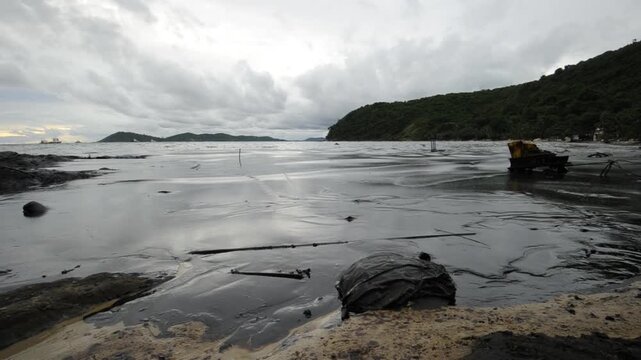 Petroleum spill mixed with other chemical substances on sea and sand surface. Pollution footages, Samet Island, Thailand.

