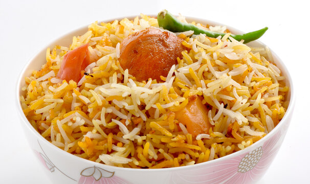 Delicious Spicy Chicken Biryani with aloo and green chili in a decorative bowl isolated on white background
