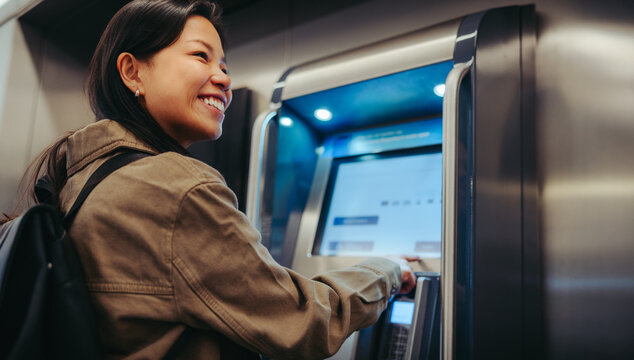 Woman buying ticket at transit kiosk during commute
