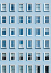 Obraz premium Elegant seamless architectural pattern featuring rows of white windows set against a soft powder blue house facade in a repetitive design, aesthetic, blue, construction