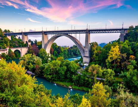 Historic Stone Arch Bridge In Bern Switzerland At Sunset Over The Turquoise Aare River Surrounded Vibrant Autumn Foliage And Colorful Pink