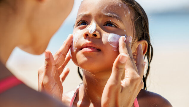 Child receiving sunscreen application on beach, sun protection, family vacation, skincare, parent-child bond, outdoor activity, summer essentials, advertising, health awareness