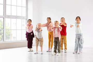 Fototapeta premium Group of happy little children showing thumbs-up in dance studio