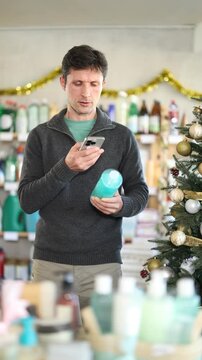 Checking expiration date of shower gel or champoo - male shopper scans QR code on label of shower gel or champoo using her smartphone. High quality 4k footage