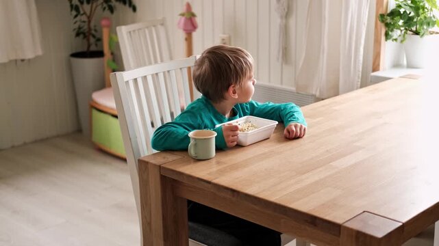 6 years old boy eats instant noodle from box. Child is eating Asian ramen. Lunch time. A good appetite. Tasty children food. Close-up portrait. Carbs dinner. Fast food. Kid eating by himself with fork