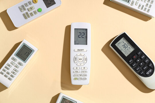 Air conditioner remote controls on beige background
