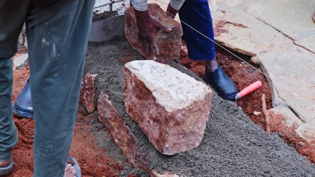 Closeup shot of placing granite stones on basement work aligning through string line at hyderabad, telangana, india. day time, stable shot, 4k.