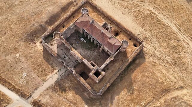 Drone flying forward reaching top down aerial view over abandoned castle