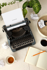 Naklejka premium Vintage typewriter, cups of coffee, crumpled paper and opened notebook on white wooden background