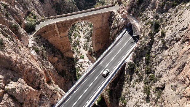 Top down drone shot flying forward over Mascarat Canyon bridges and traffic