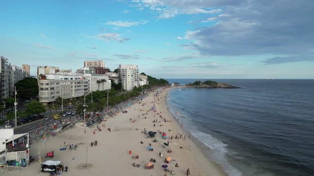 Aerial view of Arpoador beach and coastline with people, ocean and cityscape in Rio de Janeiro, Brazil