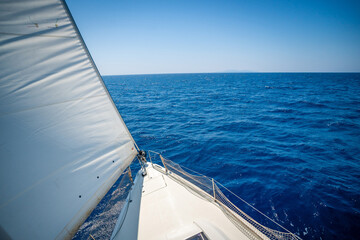 Obraz premium View from the mast down to the bow of a sailing yacht moving under full sails near Croatia. Freedom, adventure, yachting lifestyle and dynamic sea travel.