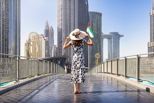 A elegant tourist woman walks through the streets of Downtown Dubai, UAE, during her city sightseeing trip