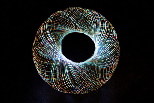 swirling light trails form a glowing torus shape with an abstract feel