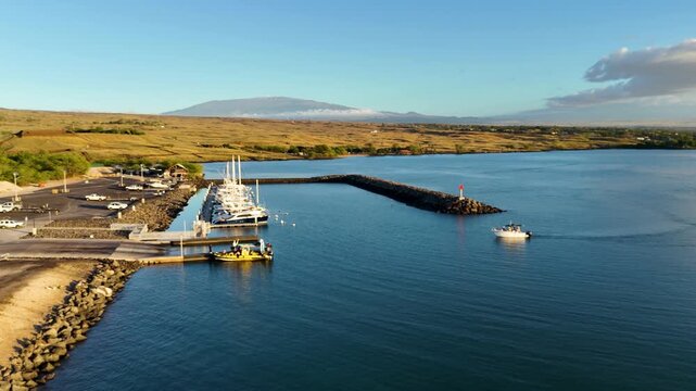 Aerial view of boats docked at Kawaihae Road harbor, with the vast ocean reflecting the sky's blue hues, Waimea, Hawaii, United States.