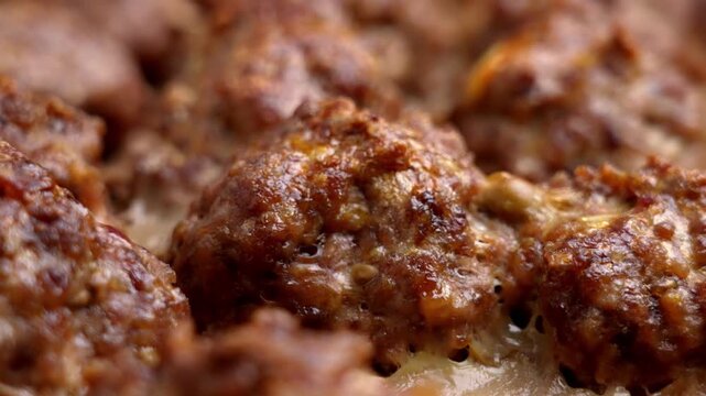 Many roasted meat balls with a golden brown crust from minced beef. Macro shot.
