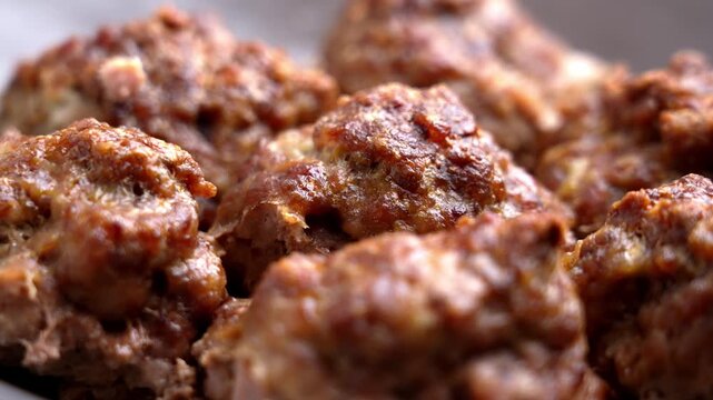 Oven-baked roasted meat cutlets with a browned crispy texture and seasoned crust in ceramic bowl. Rotation