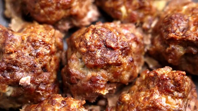 Roasted meat balls with a brown crust from minced beef and pork on ceramic dish. Top view. Rotation
