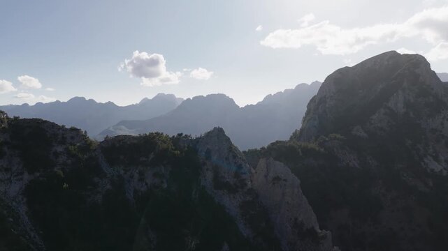 Aerial view of rugged mountain peaks and valleys, where shadows dance across the landscape, creating a scene of serene beauty, Teth, Shkoder County, Albania.