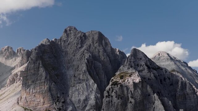 Aerial view of rugged mountain peaks piercing the clear blue sky, with sparse vegetation clinging to the steep slopes, Teth, Shkoder County, Albania.