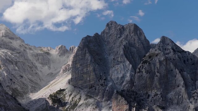 Aerial view of majestic mountains with rugged peaks under a blue sky, showcasing the natural beauty of Teth, Shkoder County, Albania.